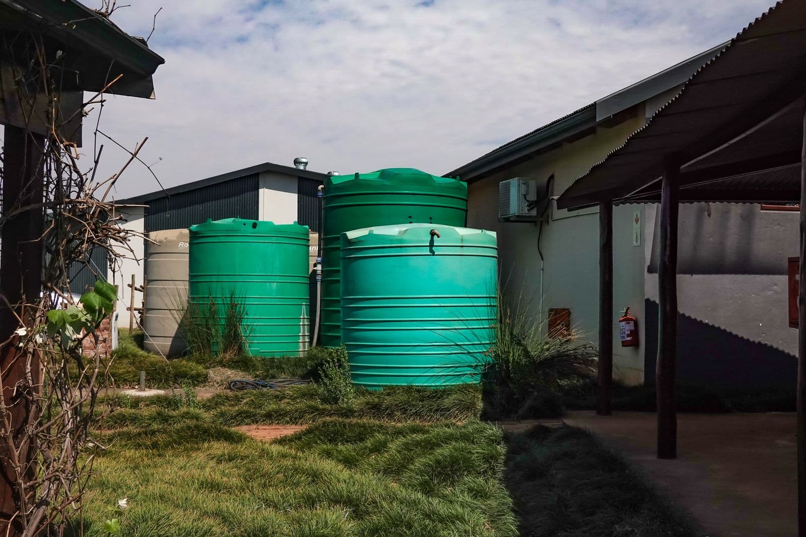 Ground-level poly water tanks installed and plumbed at a South Coast property